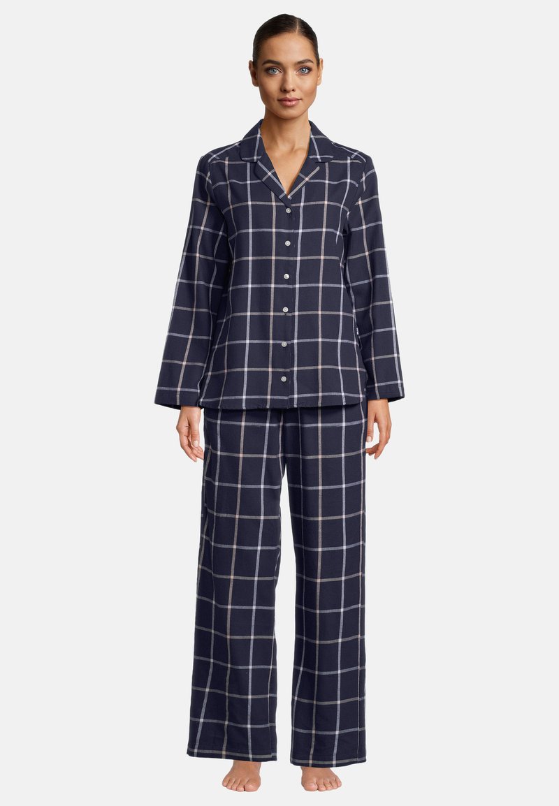 Marinblå rutiga pyjamasset gjort av mjukt tyg. Långärmad knäppblus med snedkrage, tillsammans med löst sittande byxor med vida ben.