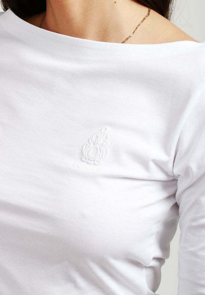 Maglietta a maniche lunghe bianca in cotone con scollatura rotonda, caratterizzata da un dettaglio del logo in rilievo sul petto. Texture liscia.