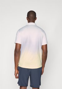 Short-sleeve polo shirt, white to yellow gradient, moisture-wicking fabric, collar, side splits, paired with navy shorts.