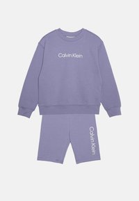 Lila bomulls sweatshirt och matchande shorts-set. Sweatshirten har en rund hals och "Calvin Klein"-logotyp. Shortsen har logotyp på sidan.