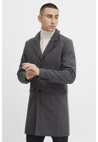 Manteau en laine gris avec un col cranté, fermeture à boutons simple, et deux poches latérales. Texture lisse, coupe légèrement ajustée.