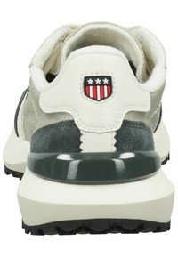 Men's athletic shoe with a mix of grey suede and white leather. Features a black outsole and a red/white shield logo at the heel.