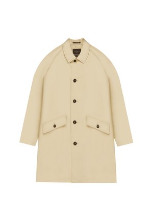 Cappotto beige al ginocchio con colletto, grandi tasche frontali e bottoni scuri. Presenta maniche raglan e una texture di tessuto liscia.