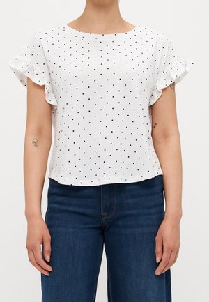 Valkoinen lyhythihainen paita mustilla pilkuilla, röyhelöhihansuuilla ja pyöreällä pääntiellä. Pehmeä kangas, rento istuvuus ja lyhyt helma.