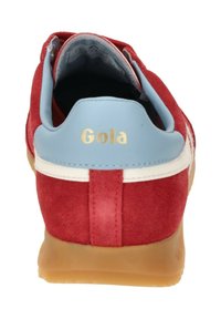 Zapatilla de ante roja con un cuello de cuero azul claro, detalles de franjas blancas y una suela de goma color beige. Presenta el logo "Gola" en dorado en el talón.