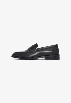 Mocassin pour homme en cuir noir avec petit talon et détail de sangle, présenté de profil sur fond blanc.