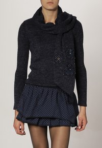 Námořnický pletený svetr s rolákem a dekorativními květinovými akcenty, v kombinaci s vrstvenou námořnickou sukni s puntíky.