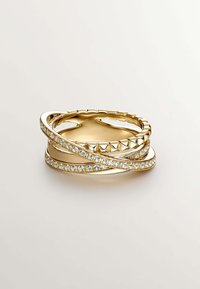 Anillos apilados de oro que presentan una banda lisa, una banda texturizada con estrías y una banda engastada con cristales claros. Forma circular con brillo.
