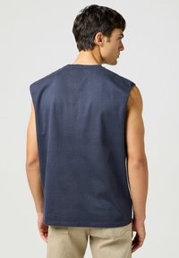 Marinblå ärmlös t-shirt i bomull med rundad halsringning och rak nederkant. Bakvy visar en smidig textur och skräddarsydd passform.