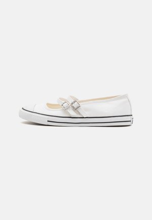 White canvas ballet flats with two silver buckle closures, rubber toe cap, and a black striped outsole. Smooth texture with minimal detailing.