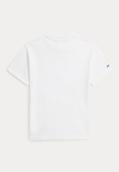 Απλό λευκό κοντομάνικο T-shirt με ένα μικρό μερικό κίτρινο και μπλε λογότυπο ορατό στο δεξί μανίκι, φαίνεται από πίσω.