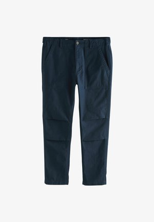 Tumed sinine puuvillane pükste regulaarses lõikes, millel on kaks külgtaskut ja väljapaistvad esipaneeli detailid. Sile tekstuur, sirged sääred.