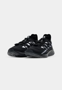 Black athletic shoes with a textured fabric upper, cushioned sole, and reflective detailing. Features lace-up closure and sturdy rubber outsole.