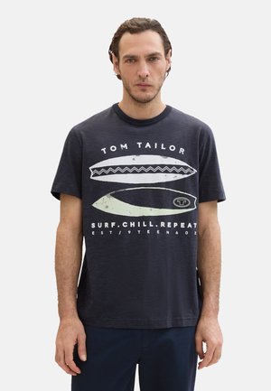 Tengerészes csíkos pamut póló fehér szörfdeszka grafikákkal és "TOM TAILOR" felirattal. Kerek nyak és rövid ujjú. Egyszerű dizájn.