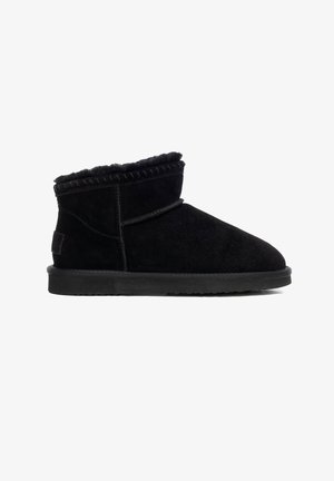 Botín de ante negro con un forro suave de piel sintética, detalle de costuras a lo largo del borde superior y suela plana de goma.