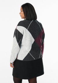 Maglione lavorato a maglia con un motivo geometrico a diamante in grigio, nero e bordeaux. Tessuto morbido con dettagli di cucitura bianca a contrasto.