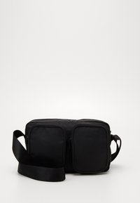 Monki Axelremsväska - black