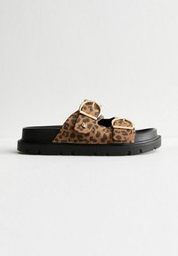 Sandaler med leopardmönster som glider på, med två gyllene spännen, svart gummisula och texturerad ovandel. Avslappnad design med öppen tå och justerbara remmar.