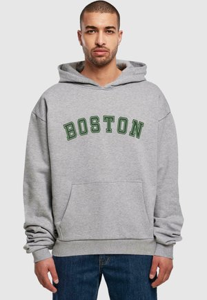 Grå hættetrøje med "BOSTON" i mørkegrøn skrifttype. Har en frontlomme og ribbetræk. Stoffet ser blødt ud med en afslappet pasform.