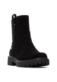 Botín de ante negro con punta redonda, superficie texturizada, lengüeta y suela de goma negra gruesa con detalles de dibujo.