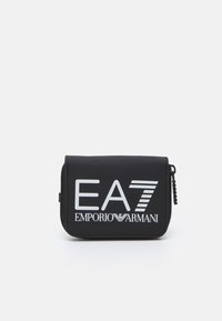 Juodas užtrauktuku uždaromas piniginė, pagaminta iš lygios medžiagos, su ryškiu baltu prekės ženklu "EA7 EMPORIO ARMANI" ir horizontaliu juostelių dizainu. Kompaktiška forma.