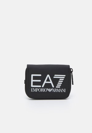 Fekete cipzáras pénztárca sima anyagból, merész fehér "EA7 EMPORIO ARMANI" márkázással és vízszintes csíkozással. Kompakt forma.