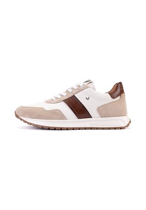 Zapatilla baja con ante beige, cuero blanco, franja de cuero marrón, cordones blancos y suela de goma marrón sobre fondo blanco.