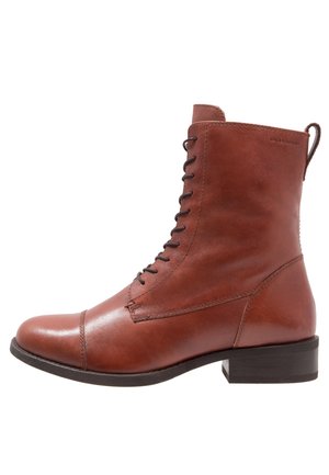 Bottine en cuir marron avec lacets à l'avant, bout renforcé, languette à l'arrière et petit talon empilé.