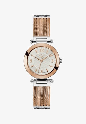 Roosa kullaga ja hõbedast võrklint, ümmargune korpus, tekstureeritud valge täpp ja roosa kullast tunniindikaator. Šveitsi mehhanism.