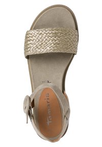 Beige Sandale mit breitem geflochtenem metallischem Riemen, weichem Wildlederfußbett und verstellbarem Schnallenverschluss an der Seite. Abgerundete Zehenpartie und niedriger Absatz.