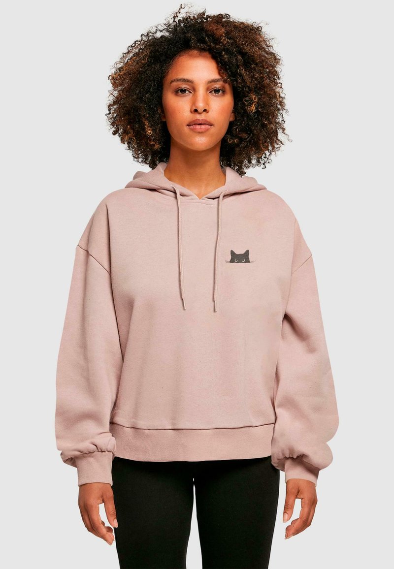 Sudadera de color rosa claro hecha de tela suave, con un diseño de un gato negro en el pecho, capucha con cordones y puños acanalados.