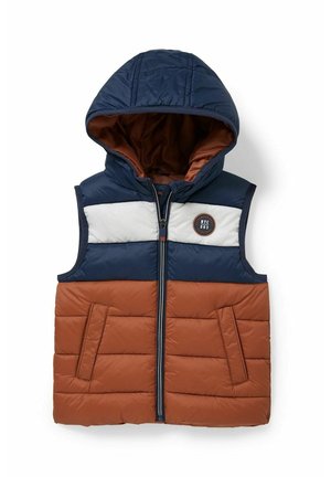 Doudoune sans manches avec capuche en blocs de couleur marine, blanc et marron, fermeture éclair sur le devant, deux poches et écusson rond NYC sur la poitrine.