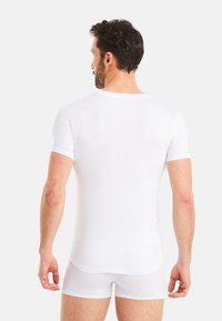 White short-sleeve t-shirt and boxer shorts set, featuring a round neckline, smooth fabric texture, and fitted design.