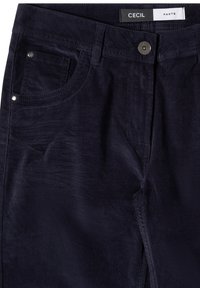 Pantalon en velours côtelé bleu foncé avec bouton et fermeture éclair à l’avant, doté de passants de ceinture, de poches avant et d’une petite étiquette de marque à l’intérieur de la ceinture.