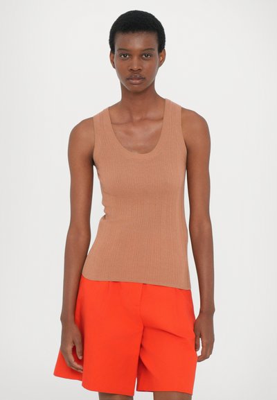 Pruun soonikuga tank top, millel on ümmargune kaelus, koos särava oranži kõrge vöökoha lühikesed püksid. Sile tekstuur, ühtlane siluett.