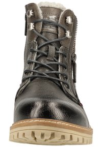 Botín negro de cuero hasta el tobillo con acabado texturizado, parte frontal con cordones, cremallera lateral y suela de goma beige. Cuenta con forro de pelo y accesorios metálicos.