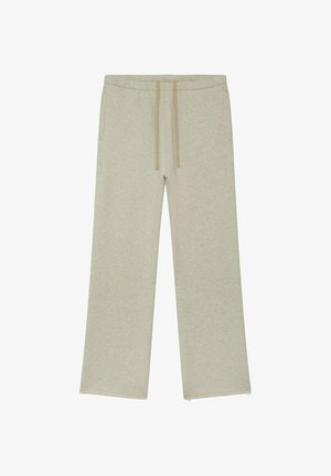 Pantalon de survêtement beige à jambes larges avec taille élastique et cordon de serrage à l'avant, doté de poches latérales et fabriqué en tissu doux mélangé de coton.