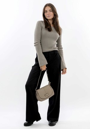 Maglietta beige a maniche lunghe con costine e maniche svasate, abbinata a pantaloni neri a gamba larga e una borsa a tracolla color beige. Scarpe nere completano il look.