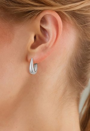 Boucle d'oreille en argent avec un design épuré et allongé. La surface lisse offre une finition polie, mettant en valeur son style minimaliste.