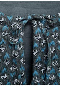 Materiał w kwiatowy wzór w odcieniach szarości z tealowymi i białymi detalami. Posiada zapięcie na sznurki przy dekolcie oraz chropowatą powierzchnię.