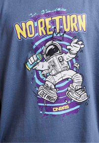 Modré tričko se pyšní grafikou astronauta, který stříká barvu, obklopeného vířícími fialovými a tyrkysovými liniemi. Nad obrázkem je text "ŽÁDNÝ NÁVRAT".