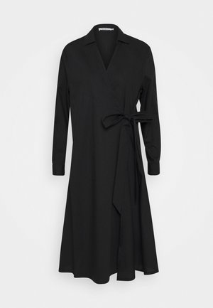 Robe portefeuille noire à manches longues avec col et fermeture à nouer sur le côté, longueur moyenne avec légère évasée.