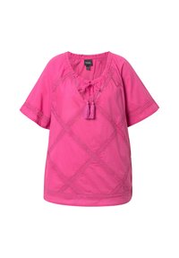 Top rosa a maniche corte con scollatura tonda, dettagli in pizzo e un legaccio con nappine sul davanti. Presenta un motivo a rombi su tutta la superficie.