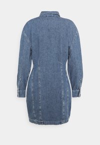 Naisen sininen denimi pitkähihainen mekko, jossa on kaulus, takasaumat ja napitettu hihansuu.