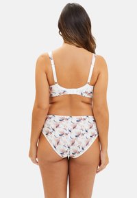 Ensemble de bikini blanc avec des motifs abstraits en pêche et bleu ; il dispose de bretelles réglables et d'une fermeture à crochet à l'arrière du haut.