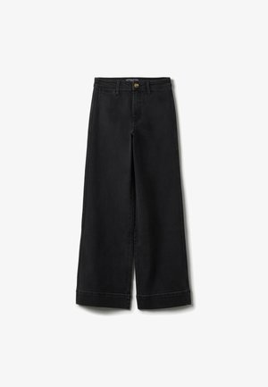 Schwarze Jeans mit weitem Bein und hoher Taille, mit Gürtelschlaufen, vorderer Knopfleiste und sichtbaren Nähten an Säumen und Nähten, flach auf weißem Hintergrund ausgelegt.