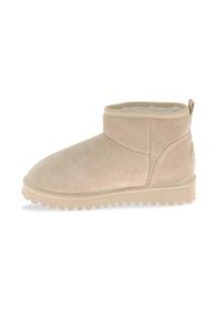 Bota de tobillo de ante beige con punta redonda, caña corta, forro interior suave y suela de goma con ranuras para mayor tracción.