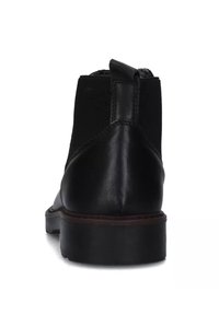 Stivale alla caviglia in pelle nera con pannello laterale elastico, punta tonda, tacco piccolo e una linguetta sul retro per facilitarne l'indossamento.