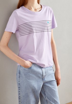 Lys lilla bomulds T-shirt med vandrette sorte striber og et lille blåt hjerteakcent. Korte ærmer og rund halsudskæring.