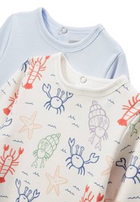 Deux chemises à manches longues : l'une bleu clair, l'autre blanche avec un imprimé de créatures marines multicolores incluant des crabes et des coquillages. Fermeture à bouton-pression au niveau du cou.